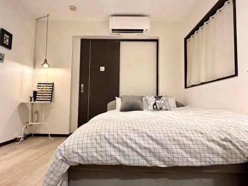 ein Schlafzimmer mit einem Bett mit einer schwarzen Tür in der Unterkunft Mori de house in kobe 2 in Kōbe