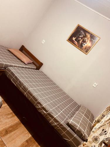a bed in a bedroom with a picture on the wall at Recanto orti in Olímpia