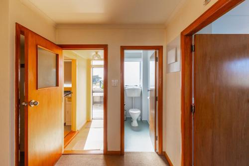 - un couloir avec une salle de bains pourvue de toilettes dans l'établissement Foxton Beach Bach 5 Star Location 2 Min Walk To Beach New Furnishings BBQ, à Foxton Beach
