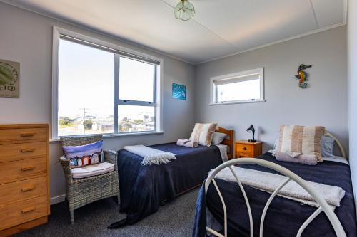 une chambre avec deux lits et une fenêtre dans l'établissement Foxton Beach Bach 5 Star Location 2 Min Walk To Beach New Furnishings BBQ, à Foxton Beach