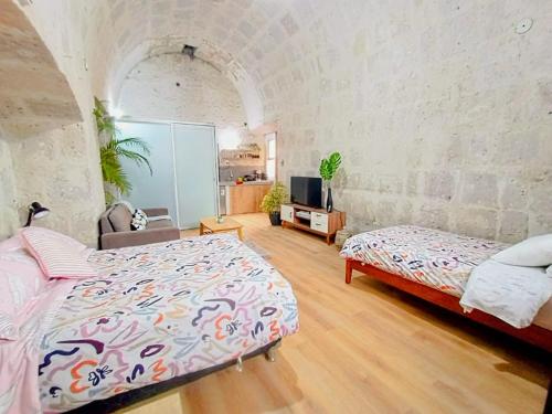 a bedroom with a bed and a tv in a room at Colonial San Lazaro Apart Hotel in Arequipa