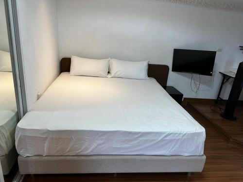 a large bed in a room with a television at Pattaya Beach Condominiumby Ahmed in Pattaya