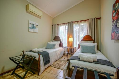 a bedroom with two beds and a window at Just Dandee in Naboomspruit