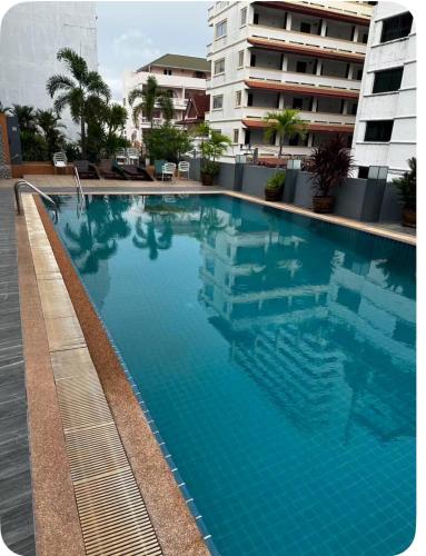 a large blue swimming pool in front of a building at Pattaya Beach Condominiumby Ahmed in Pattaya