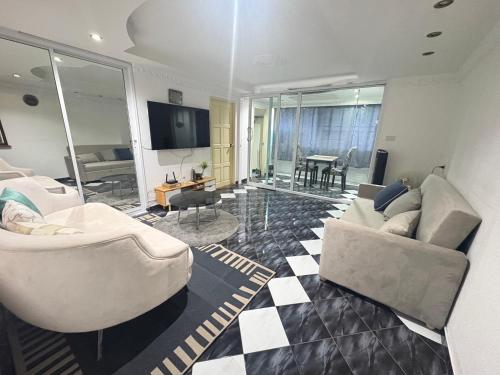 a living room with two couches and a television at Pattaya Beach Condominiumby Ahmed in Pattaya