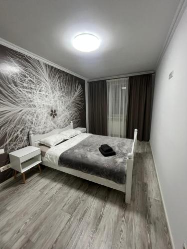 een slaapkamer met een bed en een schilderij aan de muur bij Spacious apartment with a beautiful view in Căuşeni