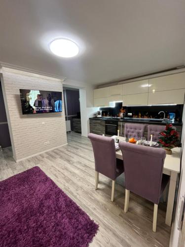 Eine Küche mit Esstisch und lila Teppich in der Unterkunft Spacious apartment with a beautiful view in Căuşeni