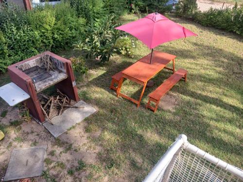 a table and a chair with an umbrella on a yard at Casa ruau in Valeria del Mar