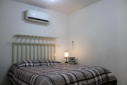 a bedroom with a bed and a tv on the wall at Casa de Ciencia, Cultura y Buena Onda in La Paz