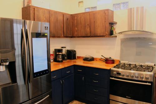 a kitchen with wooden cabinets and a stainless steel refrigerator at Casa de Ciencia, Cultura y Buena Onda in La Paz