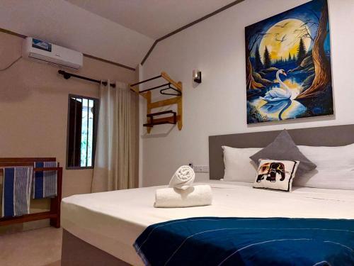 een slaapkamer met een bed met een schilderij aan de muur bij Hiri Point Villa in Dikwella