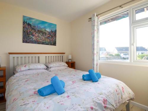 une chambre avec un lit orné de pagaies bleues dans l'établissement Merlin's Retreat, à Tintagel