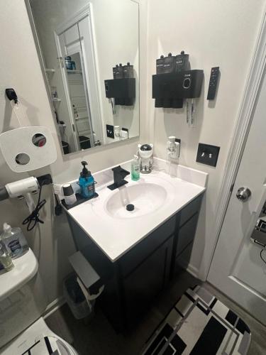 un bagno con un lavandino bianco e uno specchio di Modern Theme Private Room a Suffolk