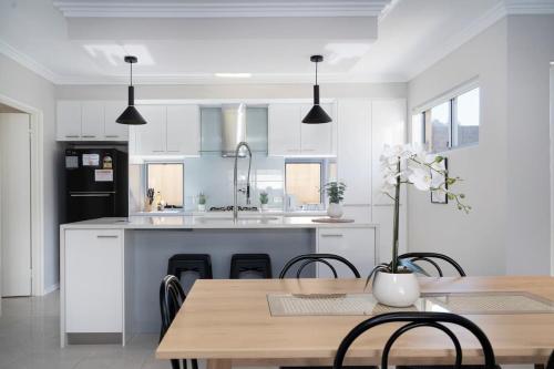 a kitchen with white cabinets and a table with chairs at 30 Modern & Quiet Retreat -Walk to Dining & Shops in Perth