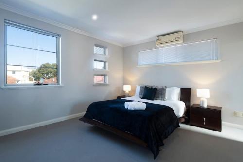 a white bedroom with a bed and a window at 30 Modern & Quiet Retreat -Walk to Dining & Shops in Perth