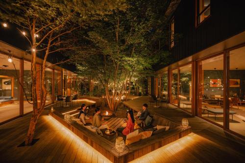 a group of people sitting on a bench in a courtyard at BEB5 Karuizawa by Hoshino Resorts in Karuizawa
