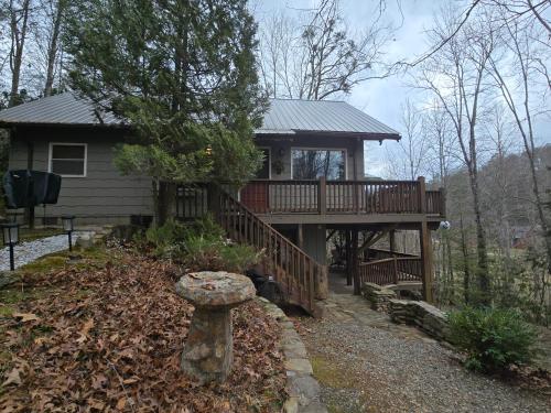 une grande maison avec une terrasse dans les bois dans l'établissement Hummingbird Hideaway - Lake Pets Hike Fish, à Hidetown