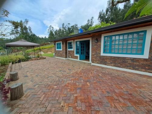 a brick house with a blue door and a patio at El Embeleso in Nobsa