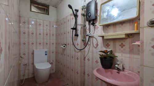 een badkamer met een roze wastafel en een toilet bij Bay Beach dom stay in Tangalle
