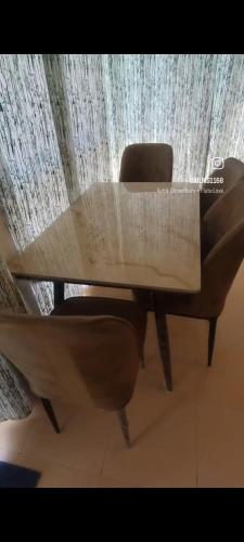 a wooden table with a chair in front of a curtain at Aarex 63B Sparsh Chalet in Dhamni