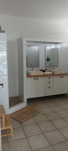 a bathroom with two sinks and two mirrors at Villa lagon bleu in Le Gosier