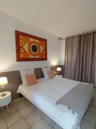 a bedroom with a large bed and a painting on the wall at Villa lagon bleu in Le Gosier