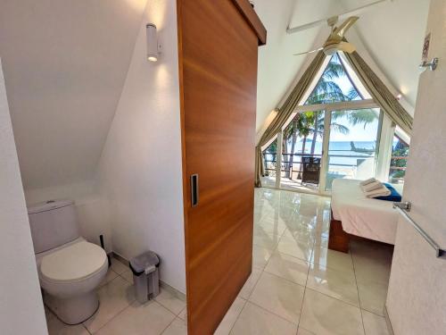a bathroom with a toilet and a window at Five Palms Beachfront Villa - by KohChangVillas in Ko Chang