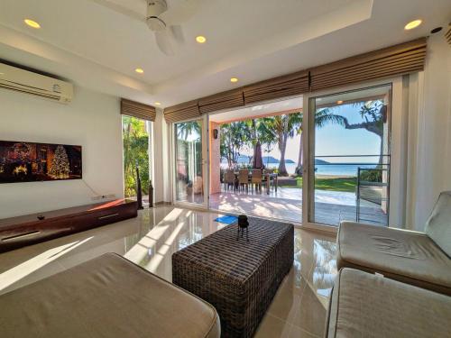 a living room with a couch and a table at Five Palms Beachfront Villa - by KohChangVillas in Ko Chang