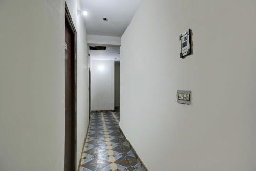 einen Flur mit weißen Wänden und Fliesenboden in der Unterkunft Hotel O by OYO Swagat in Bhiwadi