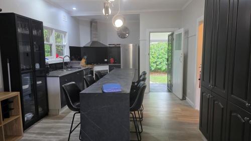 a kitchen with a black counter and black cabinets at 2 Long between breaks in Coffs Harbour