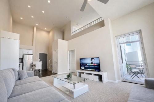 a living room with a couch and a flat screen tv at Luxury Residence Loft 3 Beds with Pool and Gym in Los Angeles