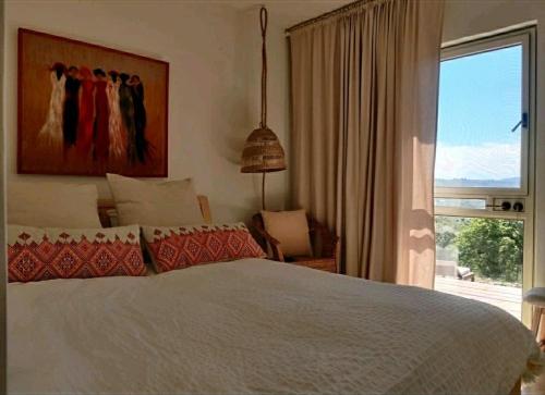 a bedroom with a bed and a large window at פינה ביער in Tsiv'on