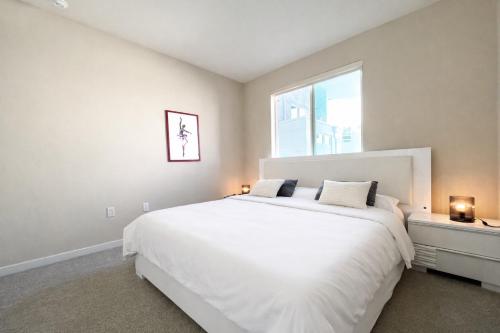 a bedroom with a large white bed and a window at Luxury Residence Loft 3 Beds with Pool and Gym in Los Angeles