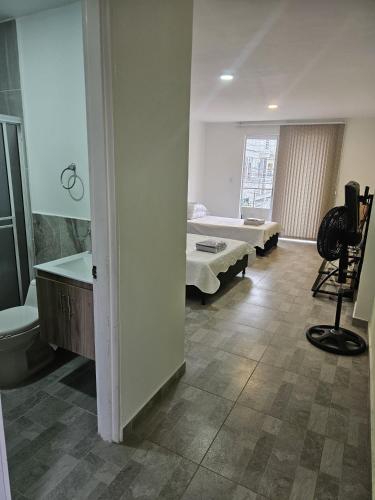ein Zimmer mit einem Bett und ein Badezimmer mit Waschbecken in der Unterkunft Alpha1 in Roldanillo