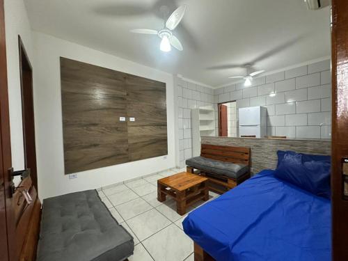 a bedroom with a blue bed and a bench at Villa Caraguá Apartamentos in Caraguatatuba