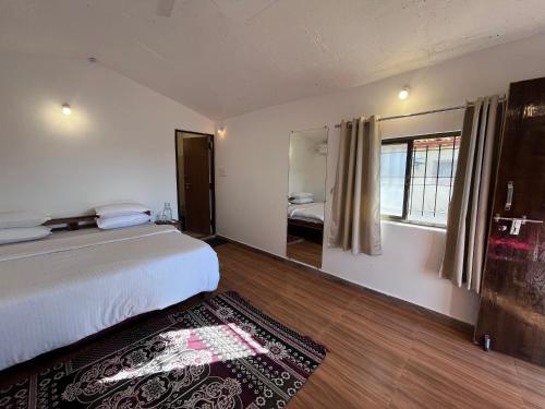 une chambre avec un lit et une grande fenêtre dans l'établissement Home in the Jungle, à Seonī