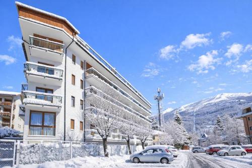 een gebouw in de sneeuw met auto's buiten geparkeerd bij Bardonest - Happy Rentals in Bardonecchia