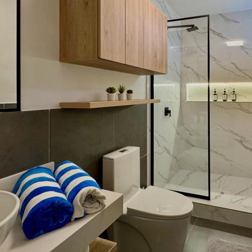 a bathroom with a toilet and a glass shower at Tiny House con Jacuzzi, Fogata y Starlink in Anta