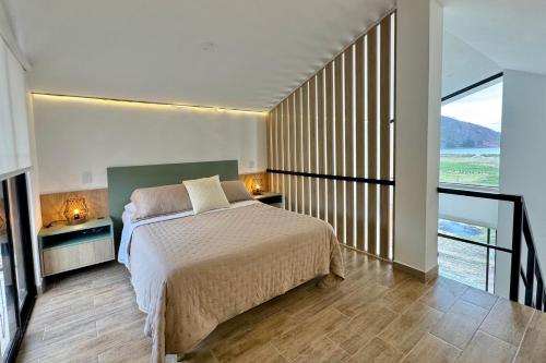 a bedroom with a large bed and a balcony at Tiny House con Jacuzzi, Fogata y Starlink in Anta