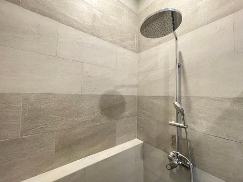 een douche met een douchekop in een badkamer bij Saltera Kedungu in Tanah Lot