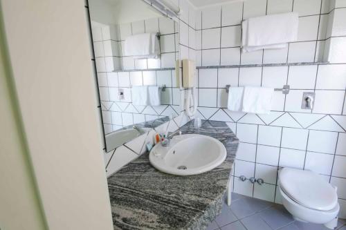 a bathroom with a sink, toilet and bathtub at Hotel Tarconte in Tarquinia
