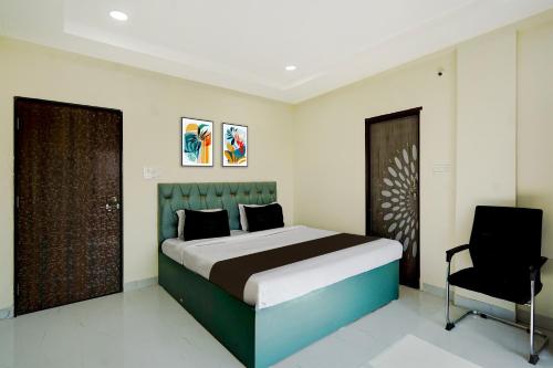 a bedroom with a large bed and a chair at Hotel O Ring Road Nagpur Formerly Glory Inn in Khāpri