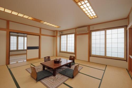 野沢温泉村にある野沢温泉 ユートピアのテーブルと椅子と窓のある部屋