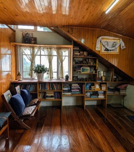 an attic room with a staircase with bookshelves at Foggy Hill's Darjeeling in Darjeeling
