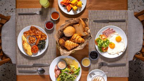 een tafel met borden ontbijt erop bij Ramada Resort by Wyndham Khao Lak in Khao Lak