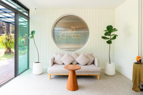 een woonkamer met een bank, een tafel en een spiegel bij Ramada Resort by Wyndham Khao Lak in Khao Lak