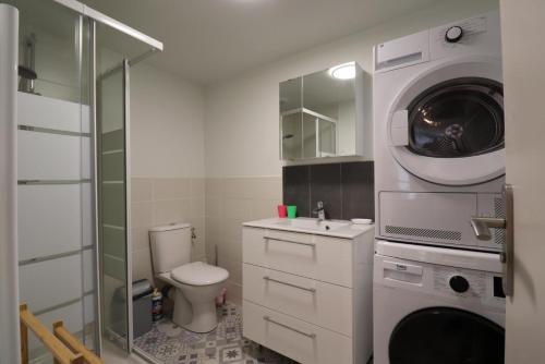 a bathroom with a toilet and a washing machine at Les 3 epines in Rennes