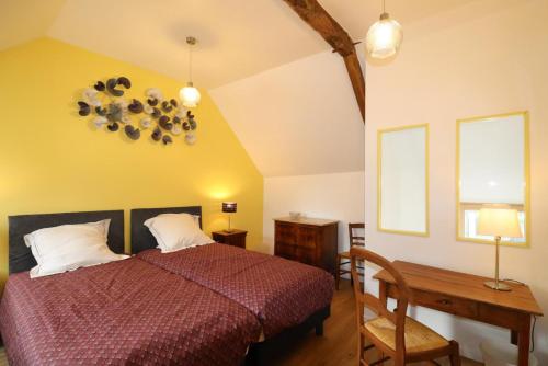 a bedroom with a bed and a table and a window at Les 3 epines in Rennes