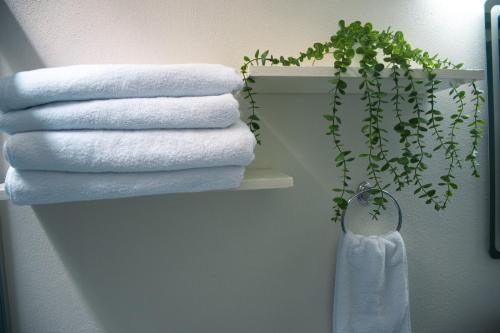 een stapel handdoeken op een plank in een badkamer bij Casa Fénix in Comala