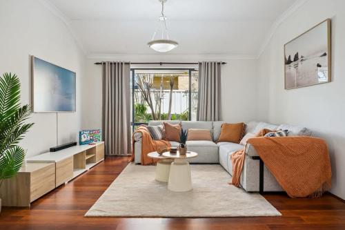 a living room with a couch and a table at Beachside Stay, Cafes Nearby, 300Mbps WiFi in Perth